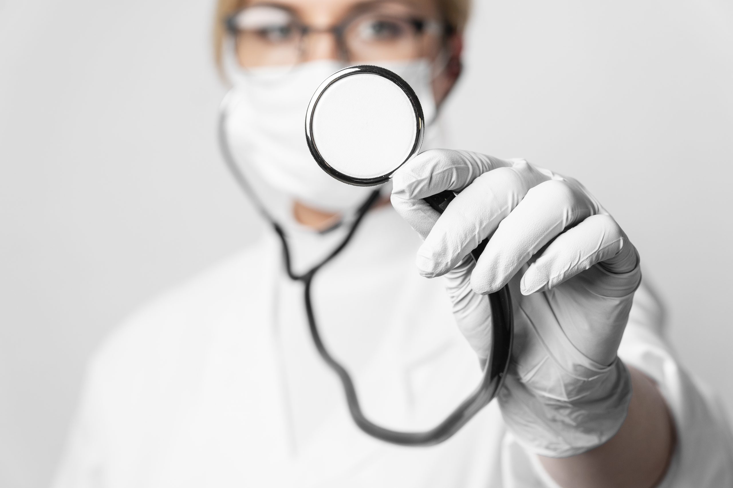 Woman wearing mask and holding a stethoscope