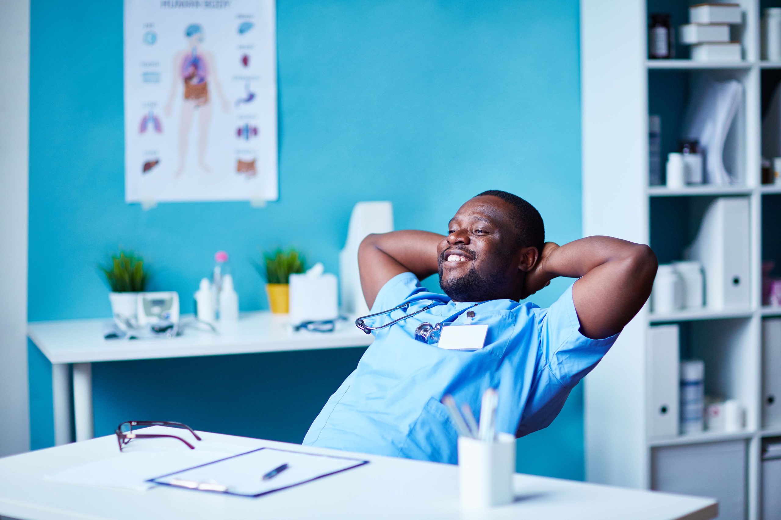 Doctor resting African male doctor with arms behind head